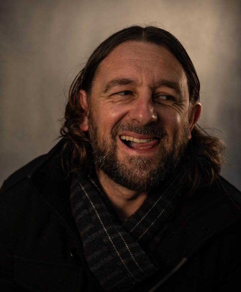 A cheeky off centre grin from Lou Chawner - Actor, Writer and Comedian