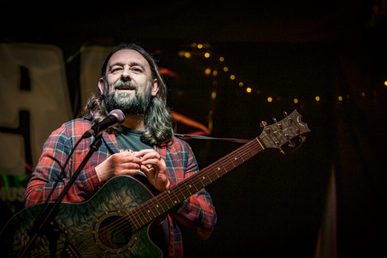 Actor, Writer and Comedian Lou Chawner performing Stand Up Comedy with his guitar