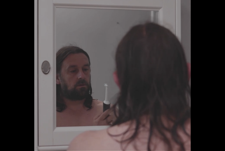 A still from Lou's first film Starlight, Lou staring at an electric toothbrush